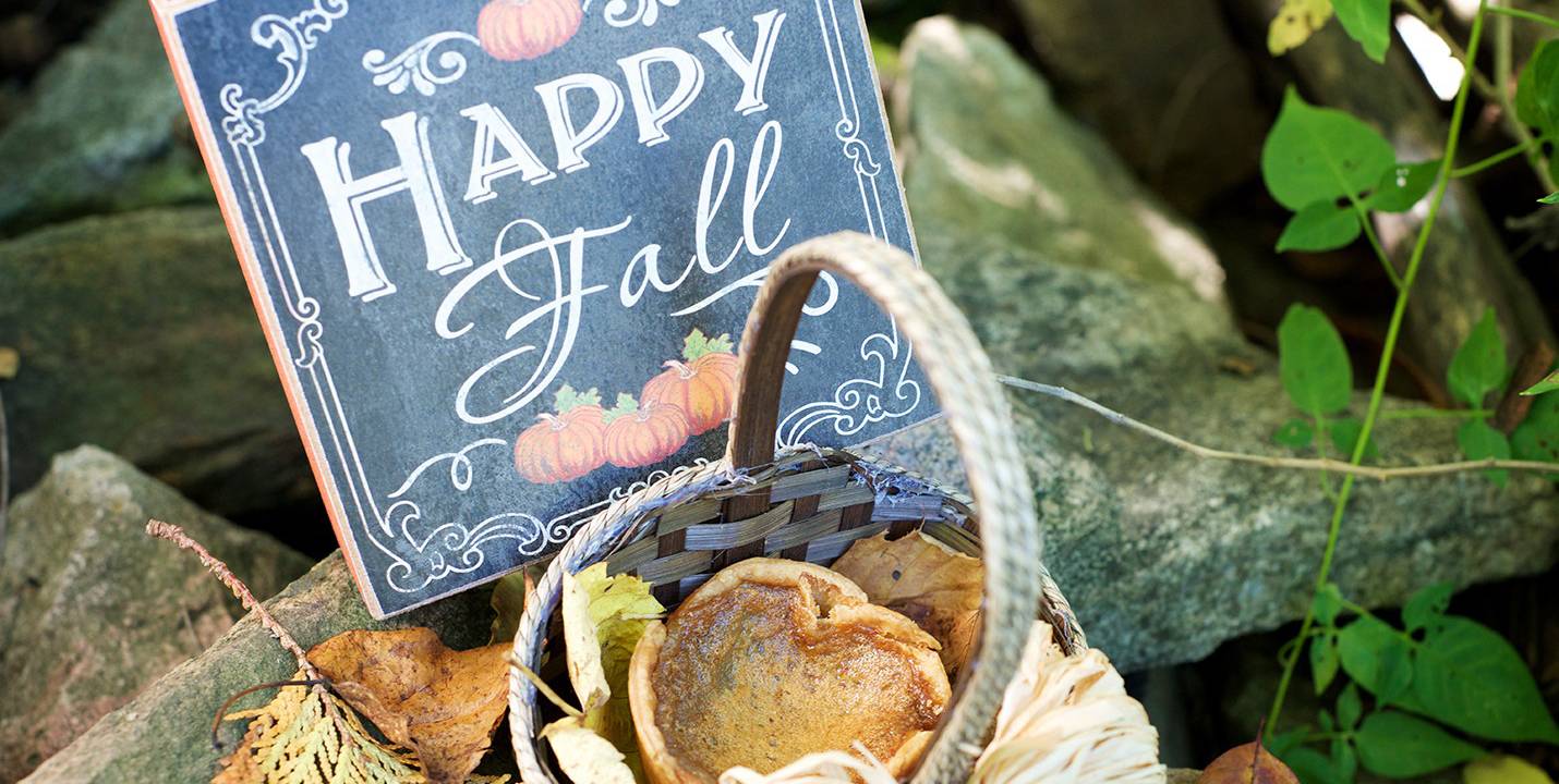 Butter tart in a small basket in front of a sign that reads "Happy Fall"