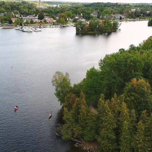Drone view shows two distant canoes approaching Lakefield