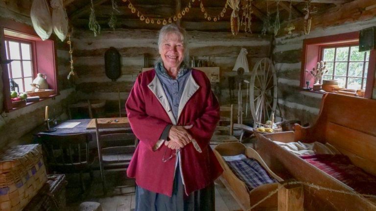 A costumed interpreter at Lang Pioneer Village poses during Applefest
