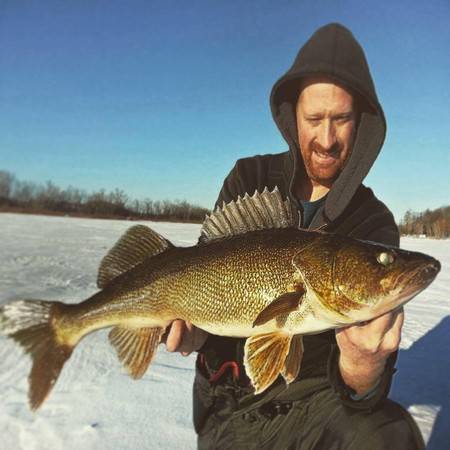 Chris Huskilson pulls his catch from an ice fishing hole