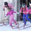 Kids play with stand-up snow sledges at the Gamiing Nature Centre