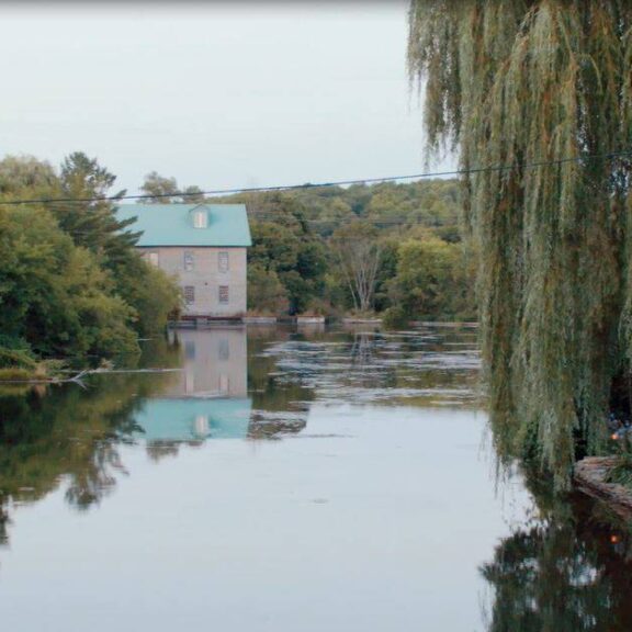 View downriver shows an historic building in the distance in Hastings, Ontario
