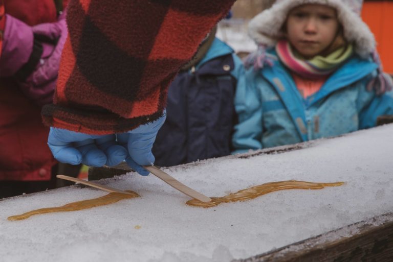 Kids watch a maple-syrup-on-snow candy making demonstration