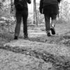 Low angle black and white photo of two hikers on a rocky trail