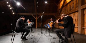 A quartet of string musicians in a barn