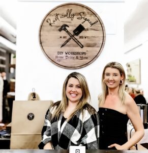 Steph Buckley and Holly Suddick stand at the counter of Rustically Signed