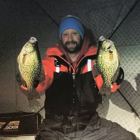 Chris Huskilson poses with his catch in an ice fishing hut