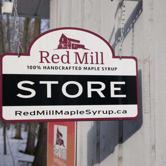 Sign reading STORE outside Red Mill Maple Syrup building