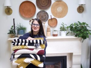 Leslie Robb of Swell Made Co holding a stack of blankets