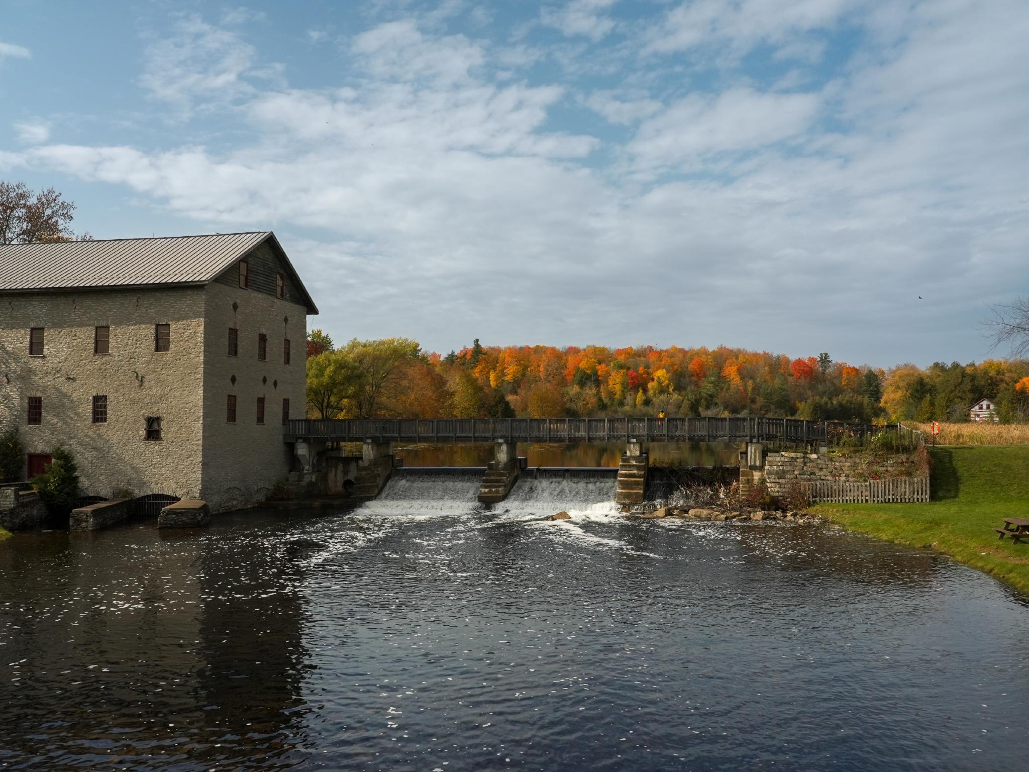 Stone mill with fall trees in the background