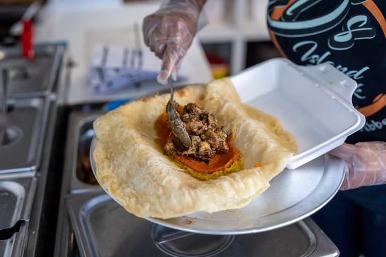 Cook scoops roti into a container