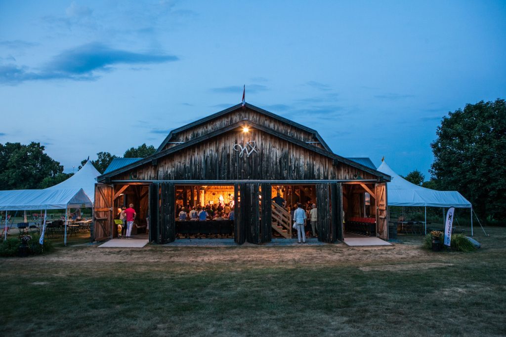 Exterior of Westben barn at night, with a show on inside
