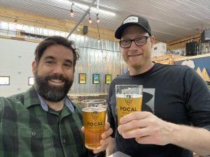 Two men toast pints of beer at Focal Brewing Co.