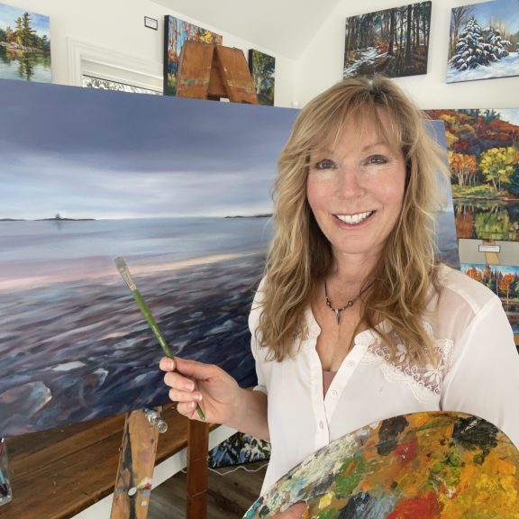 Painter Kelly Whyte poses beside one of her canvases