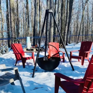 A grouping of red Muskoka chairs around a fire pit