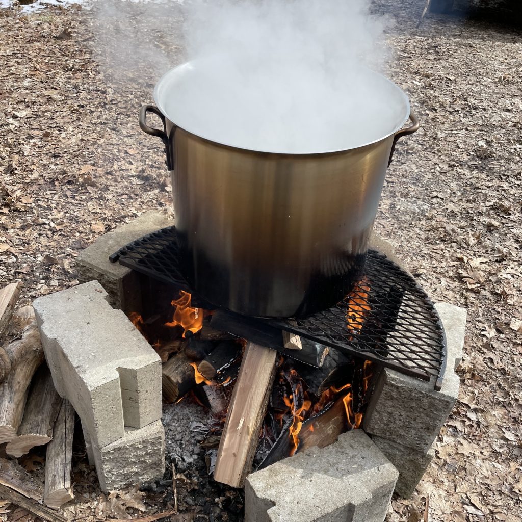 Maple sap boils over a wood fire