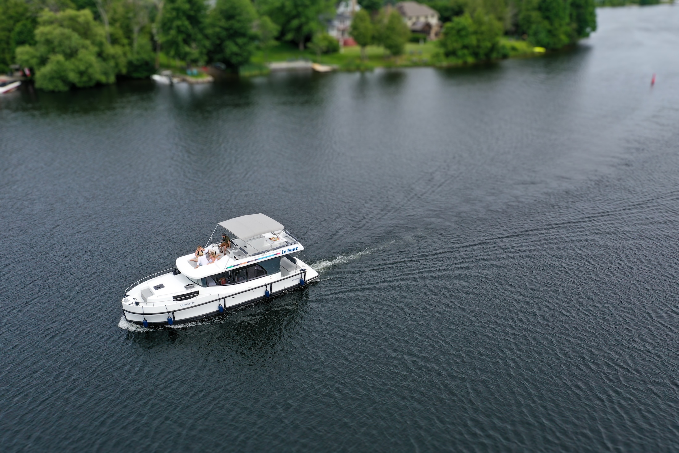 Aerial view of a houseboat travelling up a river