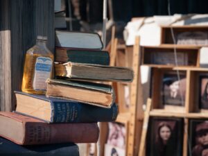 A scultural arrangement of books around a post, accented with old-fashioned items like a bottle of cod-liver oil